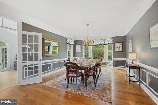 14309 Cervantes Ave, Darnestown, MD 20874 - dining room featuring a chandelier, a decorative wall, wood finished floors, and a wainscoted wall
