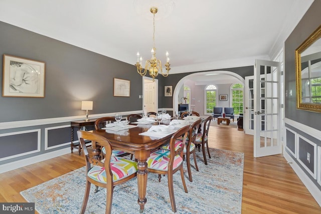 14309 Cervantes Ave, Darnestown, MD 20874 - dining space featuring arched walkways, wainscoting, a chandelier, wood finished floors, and crown molding