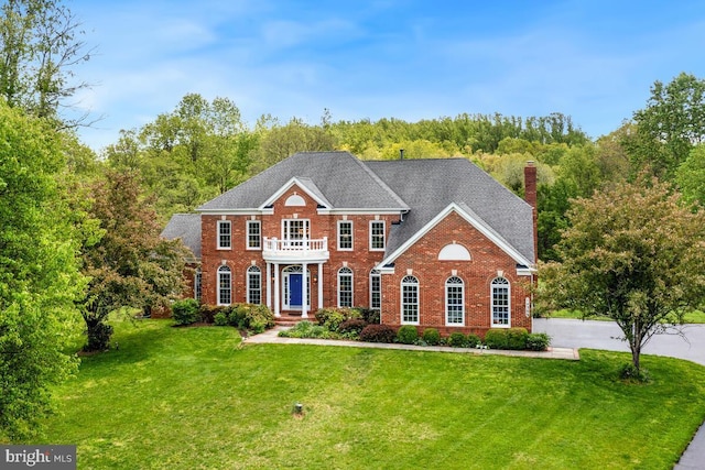 14309 Cervantes Ave, Darnestown, MD 20874 - colonial home with brick siding, a front lawn, a chimney, and a balcony