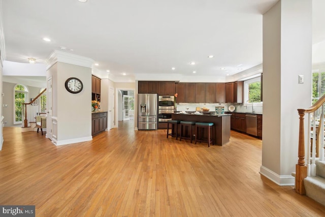 14309 Cervantes Ave, Darnestown, MD 20874 - kitchen with stainless steel appliances, a breakfast bar area, light wood-style flooring, recessed lighting, and a center island