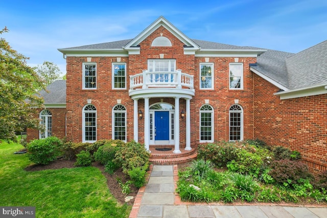 14309 Cervantes Ave, Darnestown, MD 20874 - colonial house featuring a balcony, brick siding, roof with shingles, and a front lawn