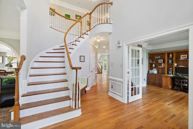 14309 Cervantes Ave, Darnestown, MD 20874 - staircase featuring arched walkways, wood finished floors, crown molding, and a high ceiling