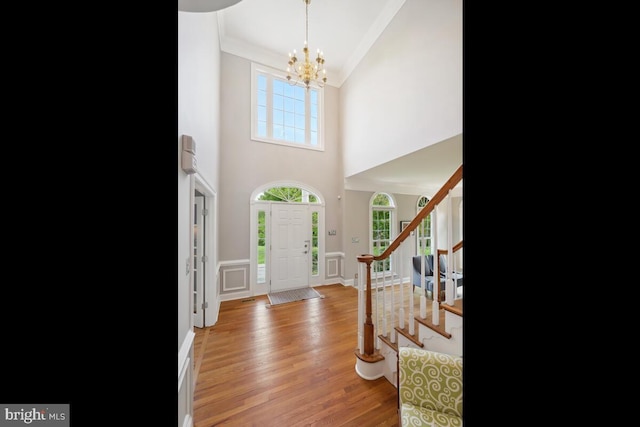 14309 Cervantes Ave, Darnestown, MD 20874 - foyer entrance with a chandelier, stairs, light wood-style flooring, and high vaulted ceiling