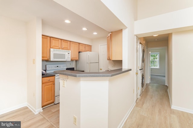 6905 Victoria Dr Unit 6905-L, Alexandria, VA 22310 - kitchen with white appliances, stacked washer / drying machine, light wood-type flooring, recessed lighting, and dark countertops