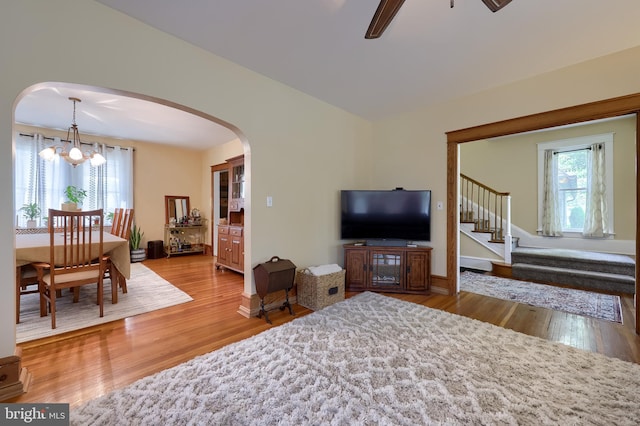 76 N Grant St, Manheim, PA 17545 - living area featuring arched walkways, a chandelier, wood finished floors, stairs, and a ceiling fan