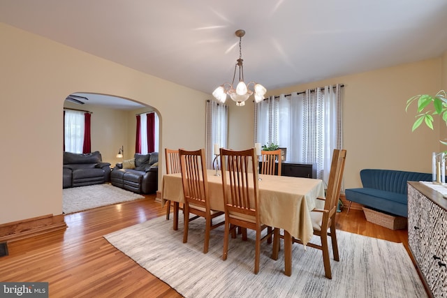 76 N Grant St, Manheim, PA 17545 - dining space with arched walkways, light wood-style floors, and a chandelier
