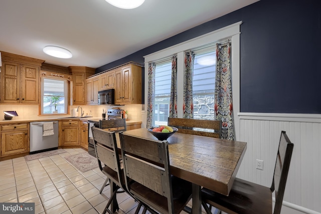76 N Grant St, Manheim, PA 17545 - kitchen featuring black appliances, light tile patterned floors, wainscoting, plenty of natural light, and decorative backsplash
