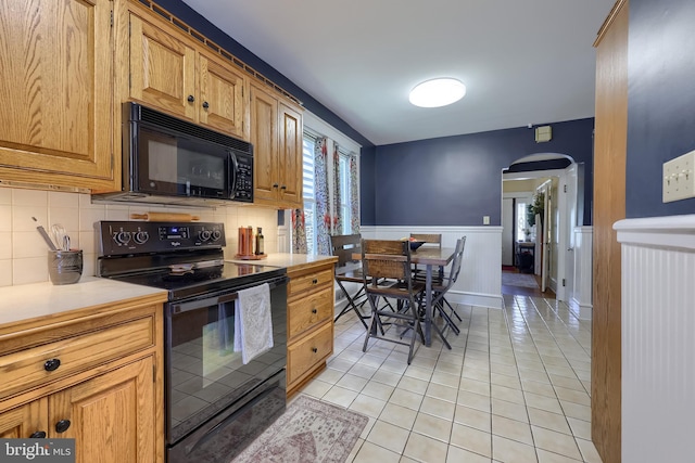 76 N Grant St, Manheim, PA 17545 - kitchen with black appliances, arched walkways, light tile patterned flooring, light countertops, and backsplash