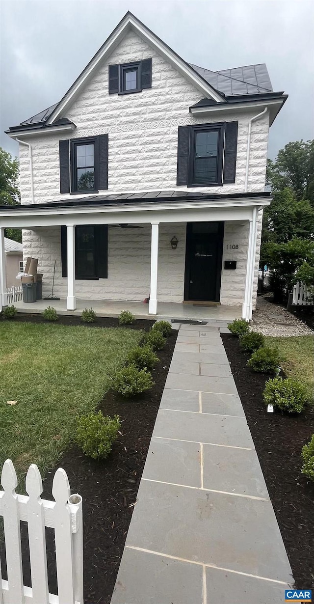 1108 E Jefferson St, Charlottesville, VA 22901 - view of front of house featuring a standing seam roof, a porch, stone siding, a metal roof, and a front yard