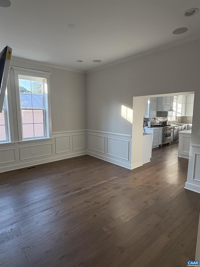 1108 E Jefferson St, Charlottesville, VA 22901 - unfurnished living room featuring crown molding, dark wood-style floors, wainscoting, and a decorative wall
