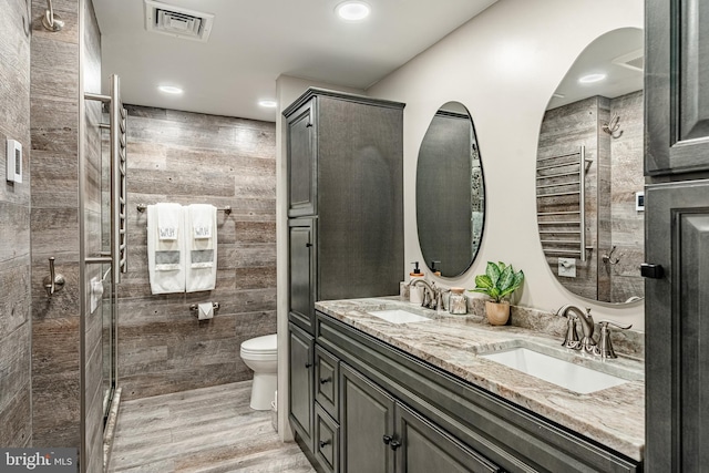 1225 Shenkel Rd, Pottstown, PA 19465 - full bathroom with a towel warming rack, double vanity, wood finished floors, recessed lighting, and a tile shower