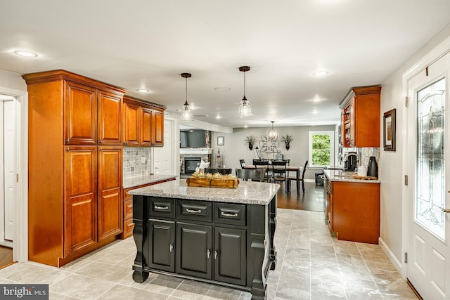1225 Shenkel Rd, Pottstown, PA 19465 - kitchen featuring brown cabinets, a center island, light stone countertops, decorative light fixtures, and recessed lighting