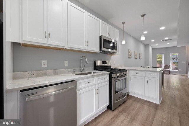 1815 N Warwick Ave, Baltimore, MD 21216 - kitchen with stainless steel appliances, a peninsula, light wood-style flooring, white cabinetry, and recessed lighting