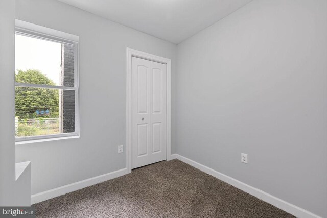1815 N Warwick Ave, Baltimore, MD 21216 - empty room featuring dark colored carpet and baseboards