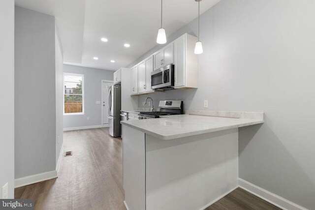 1815 N Warwick Ave, Baltimore, MD 21216 - kitchen featuring appliances with stainless steel finishes, light countertops, wood finished floors, white cabinets, and recessed lighting