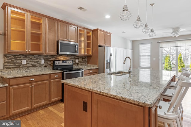 2 Smithfield Ct Unit 8, Ocean View, DE 19970 - kitchen with appliances with stainless steel finishes, brown cabinets, a center island with sink, and recessed lighting