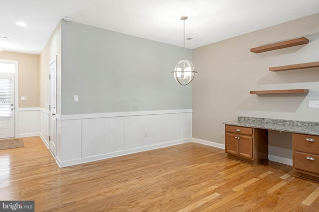 2 Smithfield Ct Unit 8, Ocean View, DE 19970 - unfurnished dining area featuring light wood-type flooring, wainscoting, built in desk, and a chandelier