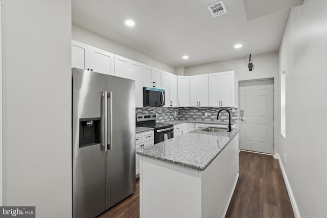 2419 Arlington St, Philadelphia, PA 19121 - kitchen featuring stainless steel appliances, light stone counters, decorative backsplash, white cabinets, and a kitchen island with sink