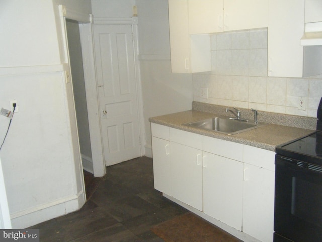 213 S 58th St, Philadelphia, PA 19139 - kitchen with black electric range oven, decorative backsplash, white cabinets, and custom exhaust hood