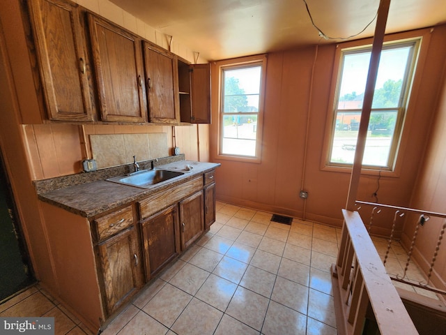 101 S Payson St, Baltimore, MD 21223 - kitchen with light tile patterned flooring, dark countertops, and brown cabinets