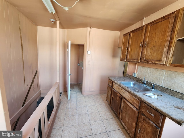 101 S Payson St, Baltimore, MD 21223 - kitchen with backsplash, light tile patterned floors, and brown cabinets