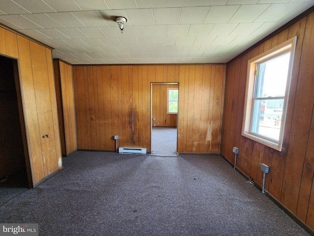 101 S Payson St, Baltimore, MD 21223 - unfurnished room featuring wooden walls, a baseboard radiator, and dark colored carpet