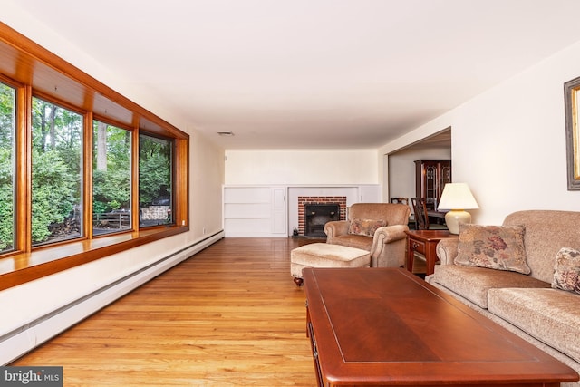 245 Greentree Dr, West Chester, PA 19382 - living area featuring a baseboard radiator, a brick fireplace, and light wood-style floors