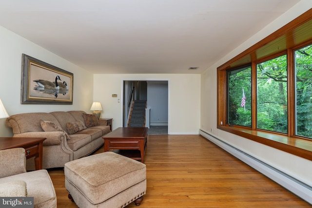 245 Greentree Dr, West Chester, PA 19382 - living room featuring baseboard heating, light wood-style flooring, and stairway