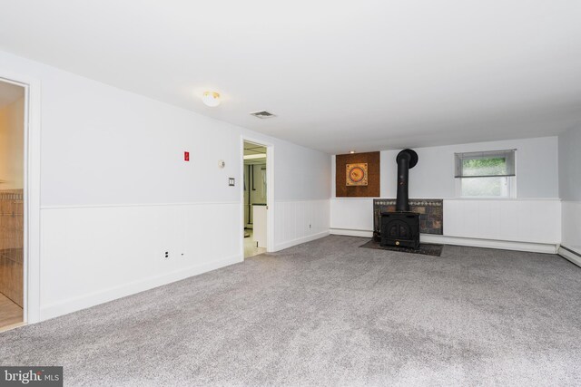 245 Greentree Dr, West Chester, PA 19382 - unfurnished living room featuring a wood stove, carpet floors, and wainscoting