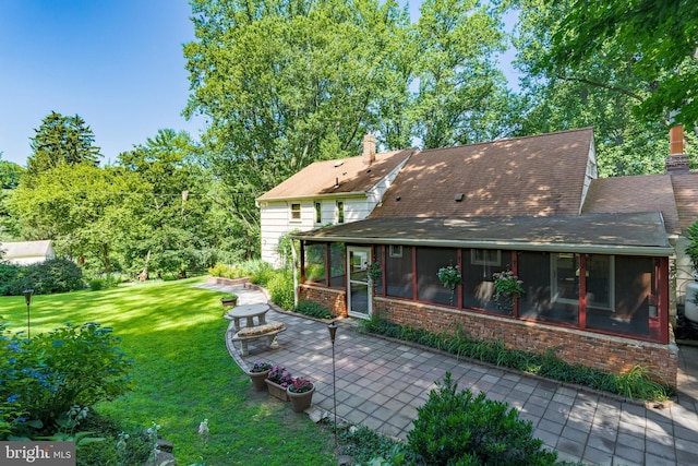 245 Greentree Dr, West Chester, PA 19382 - back of house with a sunroom, a patio area, a yard, and a chimney