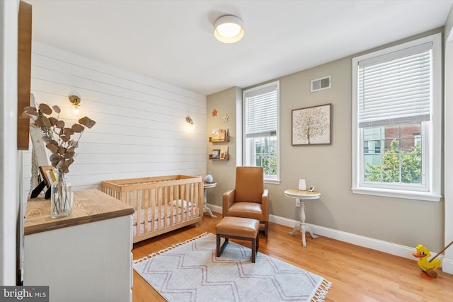 1639 S 19th St, Philadelphia, PA 19145 - bedroom with multiple windows, wood finished floors, wooden walls, and a nursery area