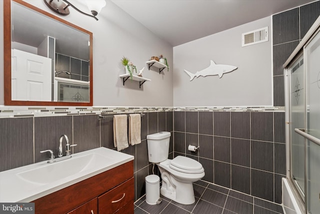 1639 S 19th St, Philadelphia, PA 19145 - bathroom with tile walls, tile patterned flooring, vanity, a wainscoted wall, and enclosed tub / shower combo