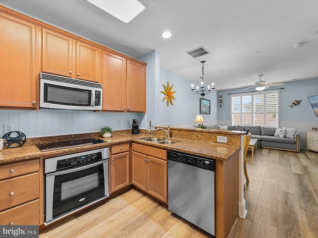 106 69th St Unit 13D, Ocean City, MD 21842 - kitchen featuring appliances with stainless steel finishes, light wood-style floors, a peninsula, open floor plan, and a chandelier
