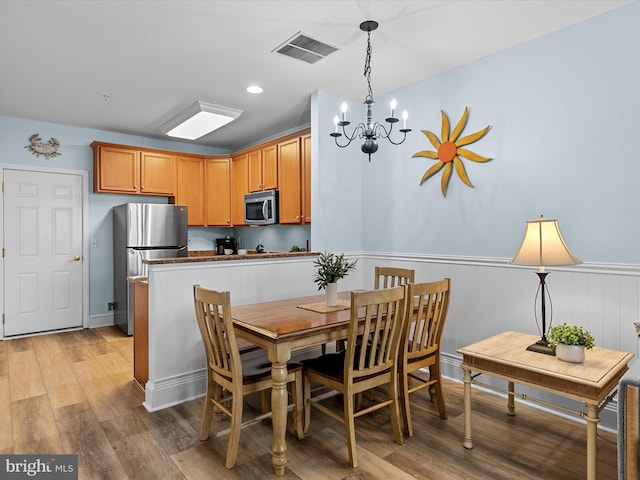 106 69th St Unit 13D, Ocean City, MD 21842 - dining room with wainscoting, a chandelier, and light wood finished floors