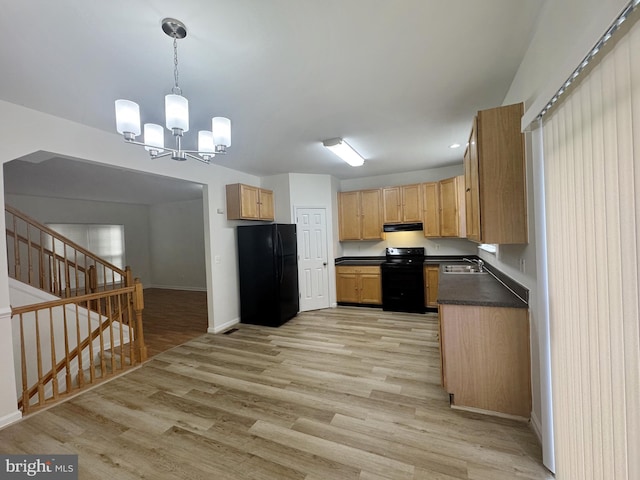 466 Sequoia Dr, Smyrna, DE 19977 - kitchen with black appliances, dark countertops, light wood-style flooring, a chandelier, and under cabinet range hood