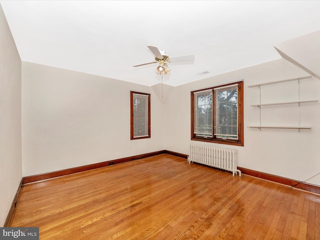 5100 Brook Green Rd, Baltimore, MD 21229 - empty room with radiator, light wood-type flooring, and ceiling fan