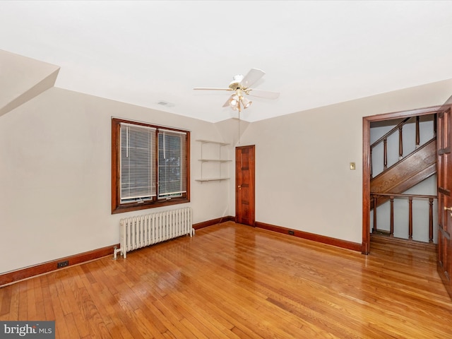 5100 Brook Green Rd, Baltimore, MD 21229 - unfurnished room featuring radiator, light wood-type flooring, stairway, and ceiling fan