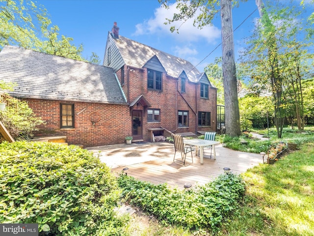 5100 Brook Green Rd, Baltimore, MD 21229 - back of property featuring a high end roof, brick siding, a wooden deck, and a chimney