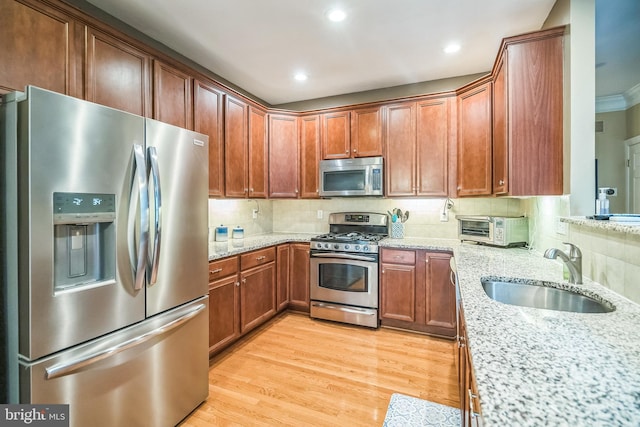 2350 Rosemont Ter, Furlong, PA 18925 - kitchen with stainless steel appliances, light stone countertops, backsplash, light wood-style flooring, and brown cabinetry