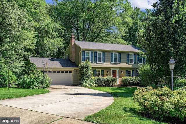 8614 Braeburn Dr, Annandale, VA 22003 - view of front of house featuring an attached garage, concrete driveway, a chimney, and a front lawn