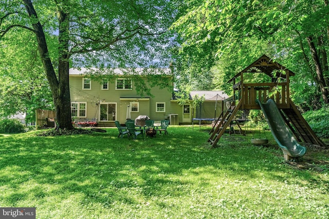 8614 Braeburn Dr, Annandale, VA 22003 - rear view of house with a playground, a lawn, and a trampoline