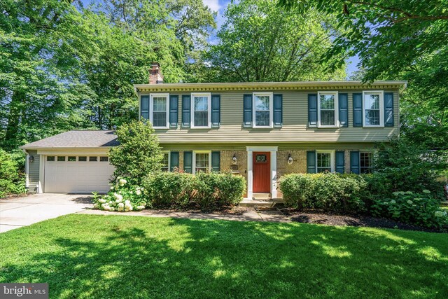 8614 Braeburn Dr, Annandale, VA 22003 - colonial home with a chimney, concrete driveway, an attached garage, and a front lawn