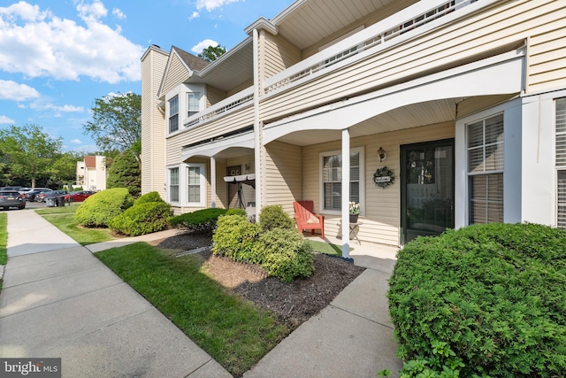 28 Powell Ct, Hightstown, NJ 08520 - view of exterior entry featuring a balcony, a chimney, and a porch