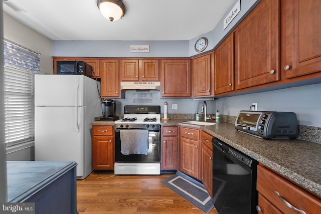 28 Powell Ct, Hightstown, NJ 08520 - kitchen with black dishwasher, range with gas stovetop, freestanding refrigerator, under cabinet range hood, and brown cabinets