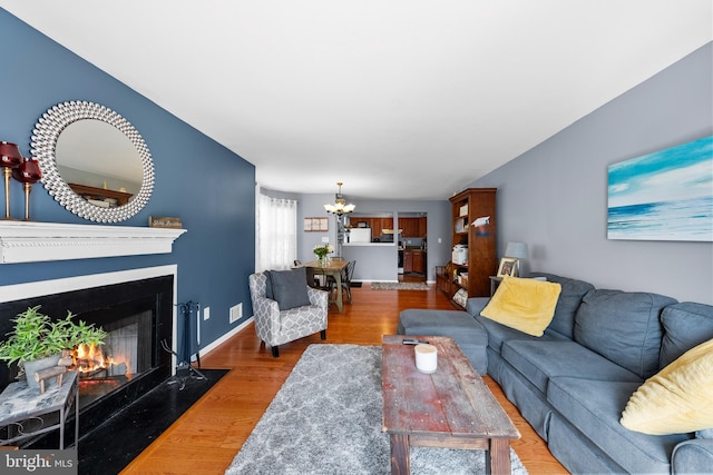 28 Powell Ct, Hightstown, NJ 08520 - living room featuring a chandelier, wood finished floors, and a fireplace with flush hearth
