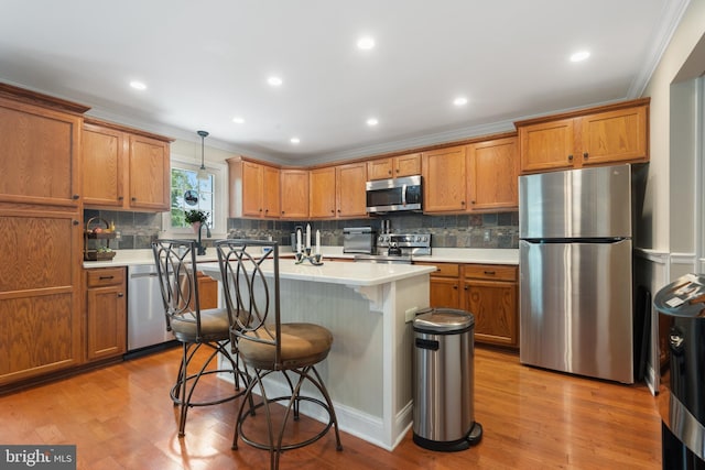 154 S Main St, Dublin, PA 18917 - kitchen featuring stainless steel appliances, ornamental molding, brown cabinets, backsplash, and a kitchen island