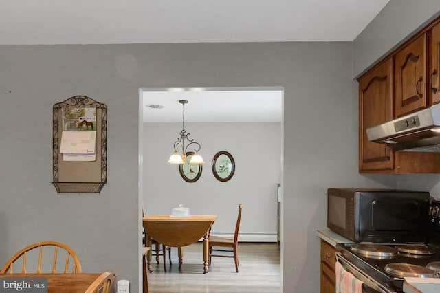 937 Meadow Ln, Millersburg, PA 17061 - kitchen with black microwave, under cabinet range hood, brown cabinetry, a chandelier, and electric stove