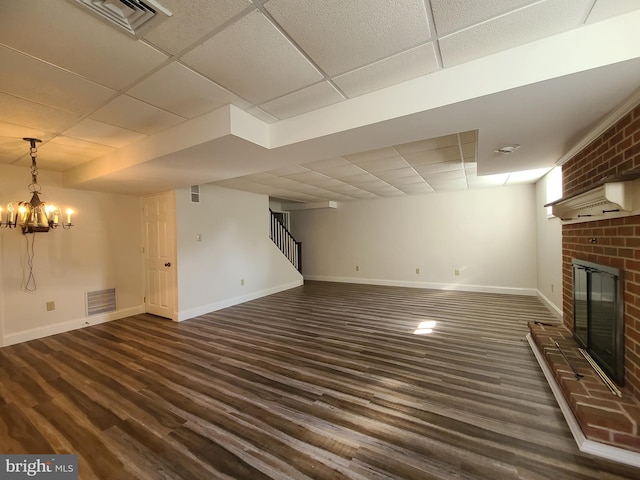520 Juniper St, Denver, PA 17517 - unfurnished living room featuring a drop ceiling, dark wood-style floors, stairs, a fireplace, and a chandelier