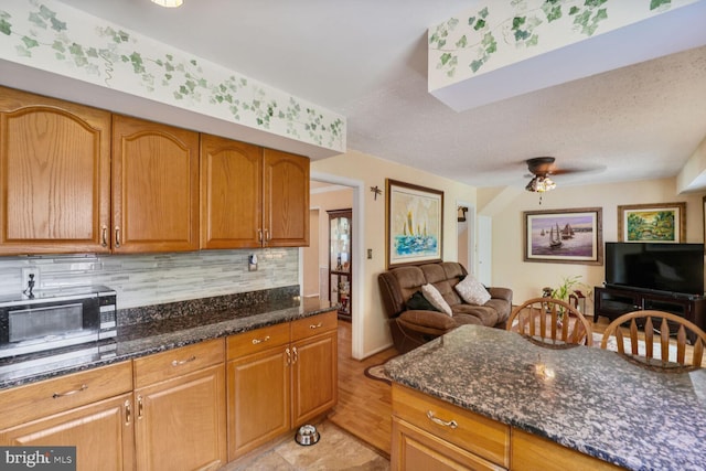 12502 Kilbourne Ln, Bowie, MD 20715 - kitchen with open floor plan, decorative backsplash, dark stone counters, and ceiling fan