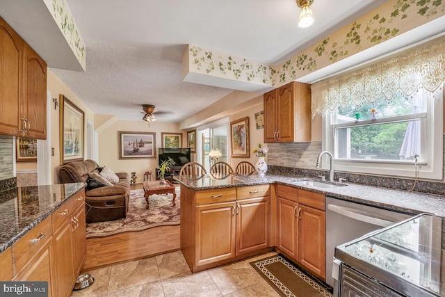 12502 Kilbourne Ln, Bowie, MD 20715 - kitchen featuring open floor plan, brown cabinets, dark stone counters, and a textured ceiling